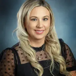 “Heather Larson, YScreen Program Coordinator, smiling in a professional headshot with a soft blue background.”